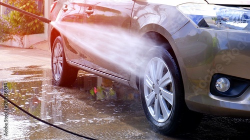Manual car washing with high pressure water jet at home, self car washing concept  © Prapat