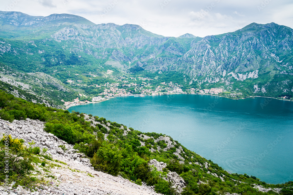 Montenegro, View to risan village in kotor bay at waterside surrounded by majestic mountains nature landscape covered by green vegetation