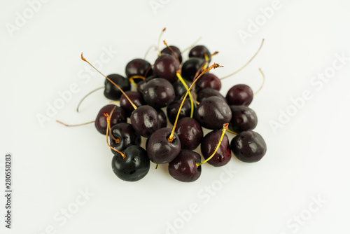 pile of fresh organic ripe black cherries isolated on white background