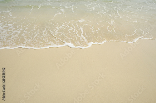 Tropical beach with white coral sand and calm wave with space for text background                   