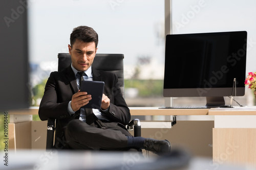Businessman sitting and using  tablet computer..