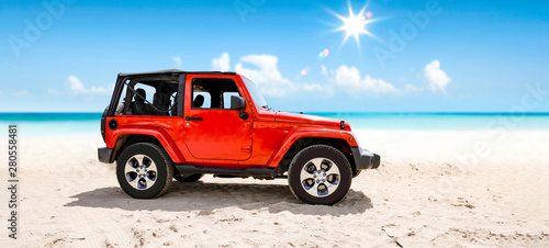 A red jeep on sandy beach a...