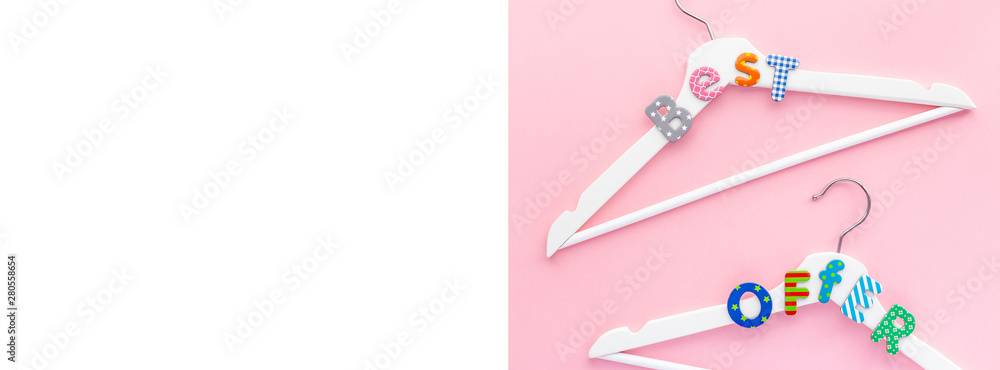 White hangers with sale text on pink background White hangers with sale text on pink background