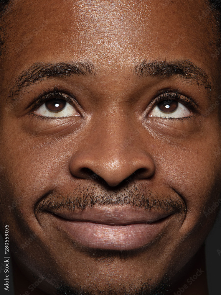 Obraz premium Close up portrait of young and emotional african-american man. Highly detail photoshot of male model with well-kept skin and bright facial expression. Concept of human emotions. Looking up and smile.