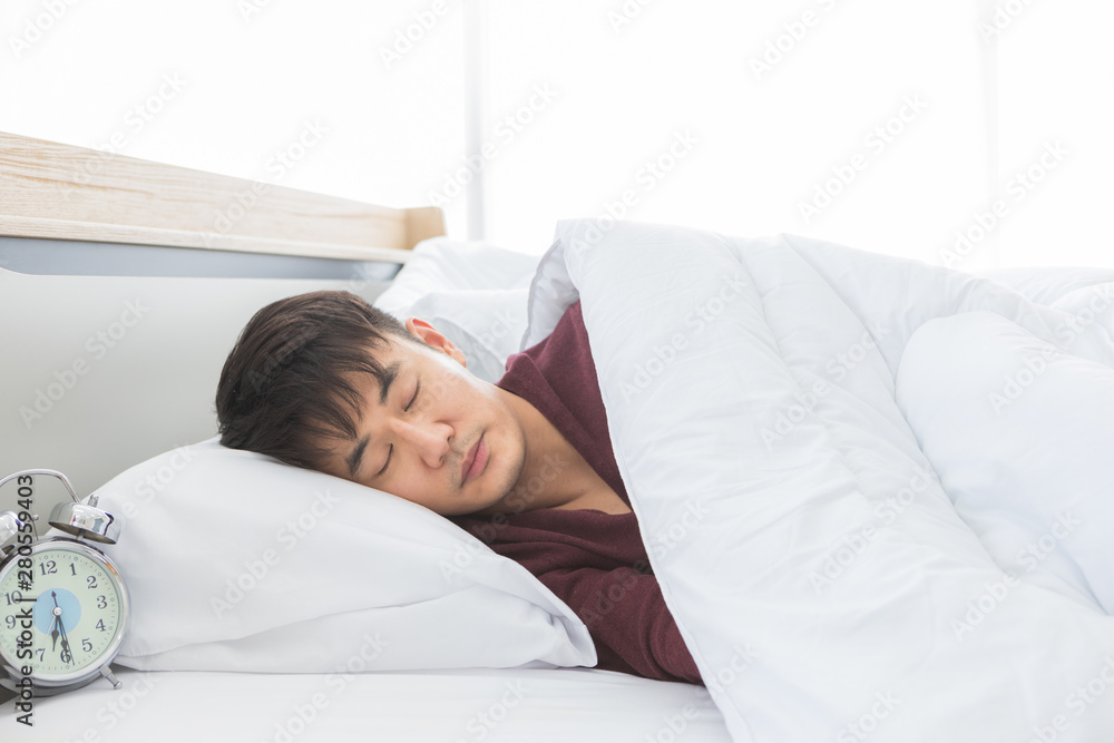 Asian man lie on one's side on the bed..