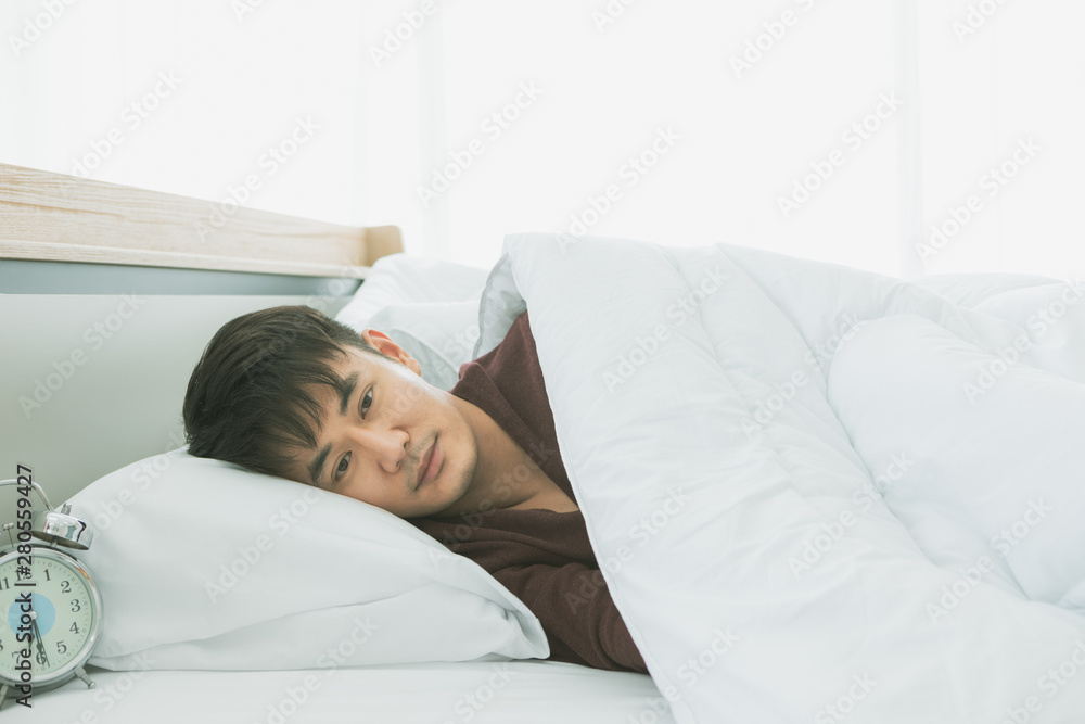 Asian man lie on one's side on the bed.. Asian man lie on one's side on the bed..