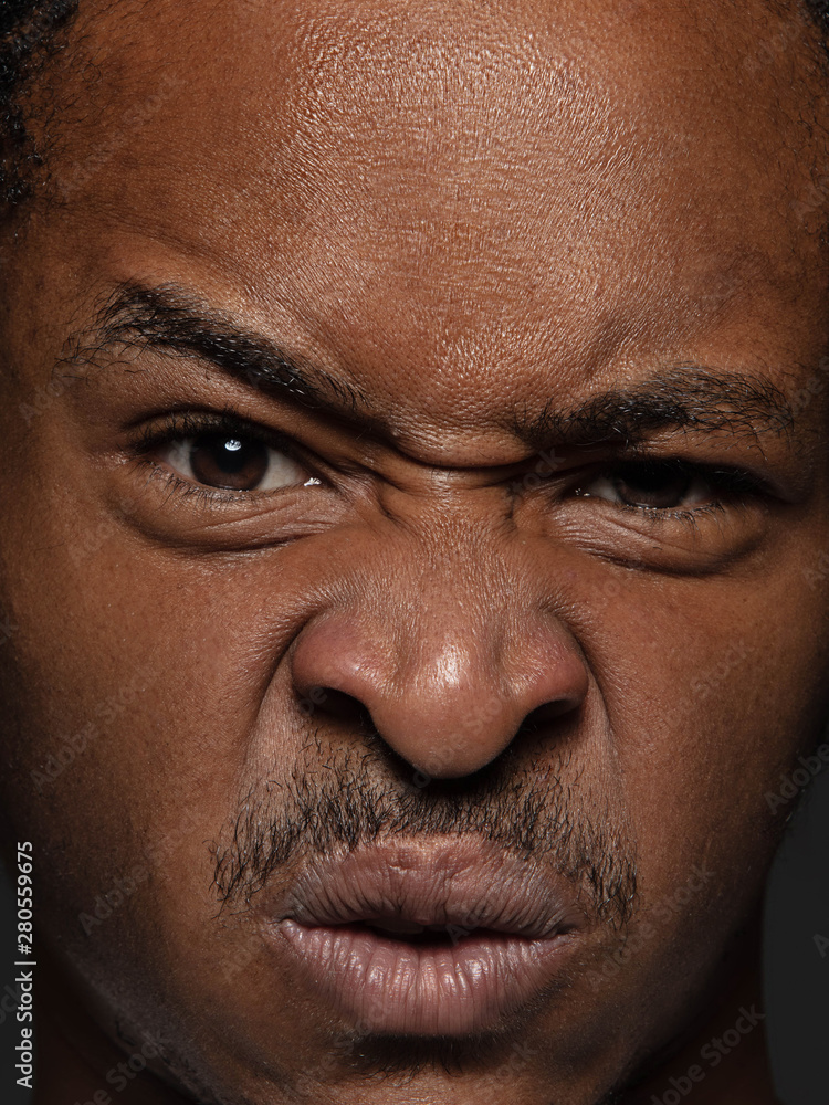 Close up portrait of young and emotional african-american man. Highly detail photoshot of male model with well-kept skin and bright facial expression. Concept of human emotions. Outraged. Close up portrait of young and emotional african-american man. Highly detail photoshot of male model with well-kept skin and bright facial expression. Concept of human emotions. Outraged.