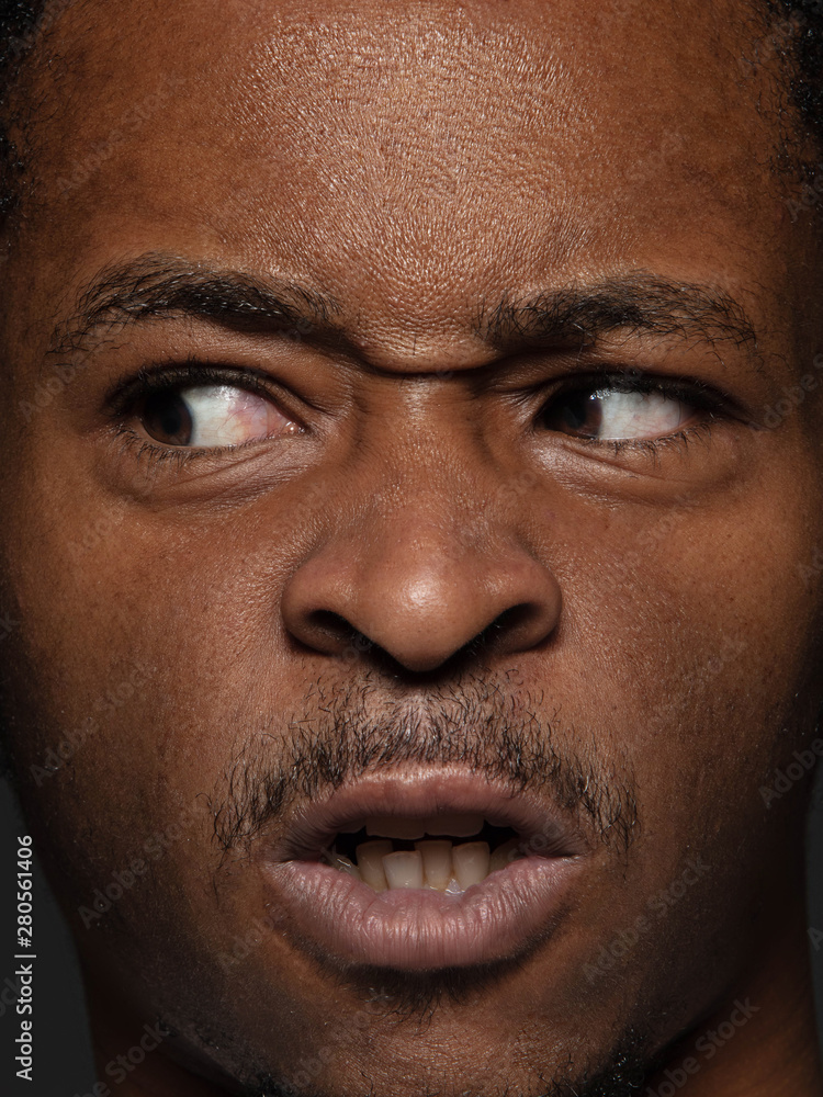 Obraz premium Close up portrait of young and emotional african-american man. Highly detail photoshot of male model with well-kept skin and bright facial expression. Concept of human emotions. Angry, agressive.