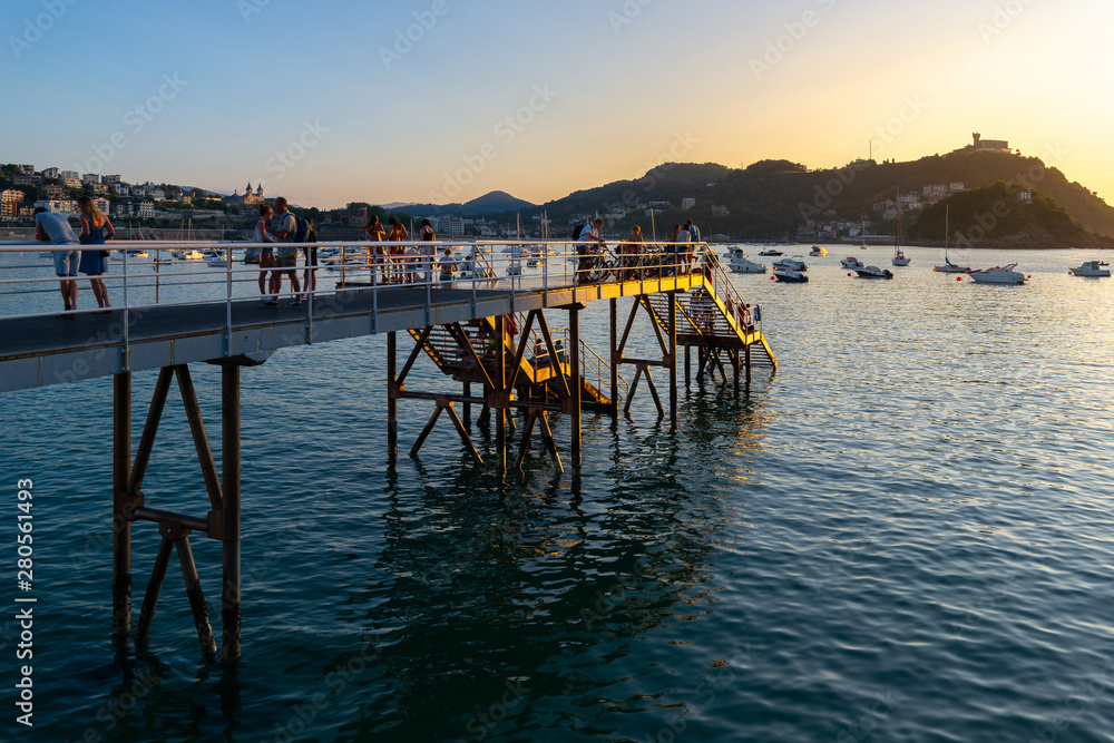 Blurred people over the pier at Club Nautico (Yacht Club) at sunset, Donostia-San Sebastian, Spain Blurred people over the pier at Club Nautico (Yacht Club) at sunset, Donostia-San Sebastian, Spain