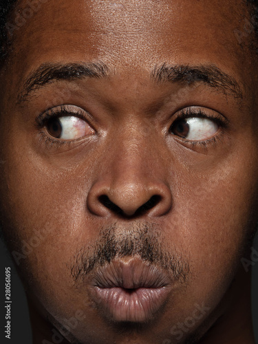 Close up portrait of young and emotional african-american man. Highly detail photoshot of male model with well-kept skin and bright facial expression. Concept of human emotions. Looking at side.