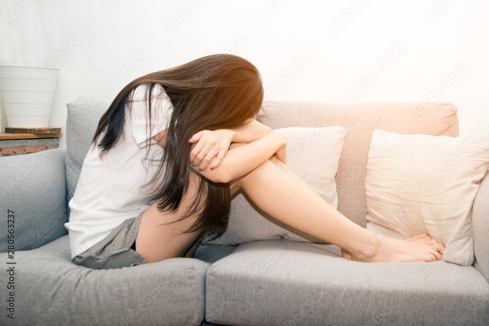 Asian woman with severe migraine headache holding hands to head on white background.. Asian woman with severe migraine headache holding hands to head on white background..