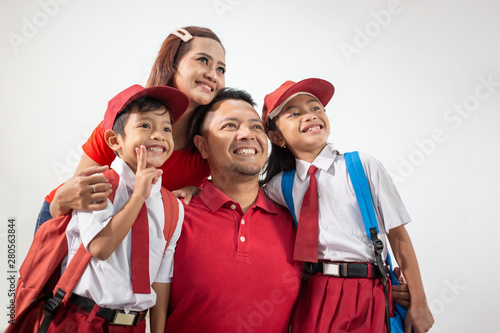 happy indonesian student with uniform smiling to camera with parent