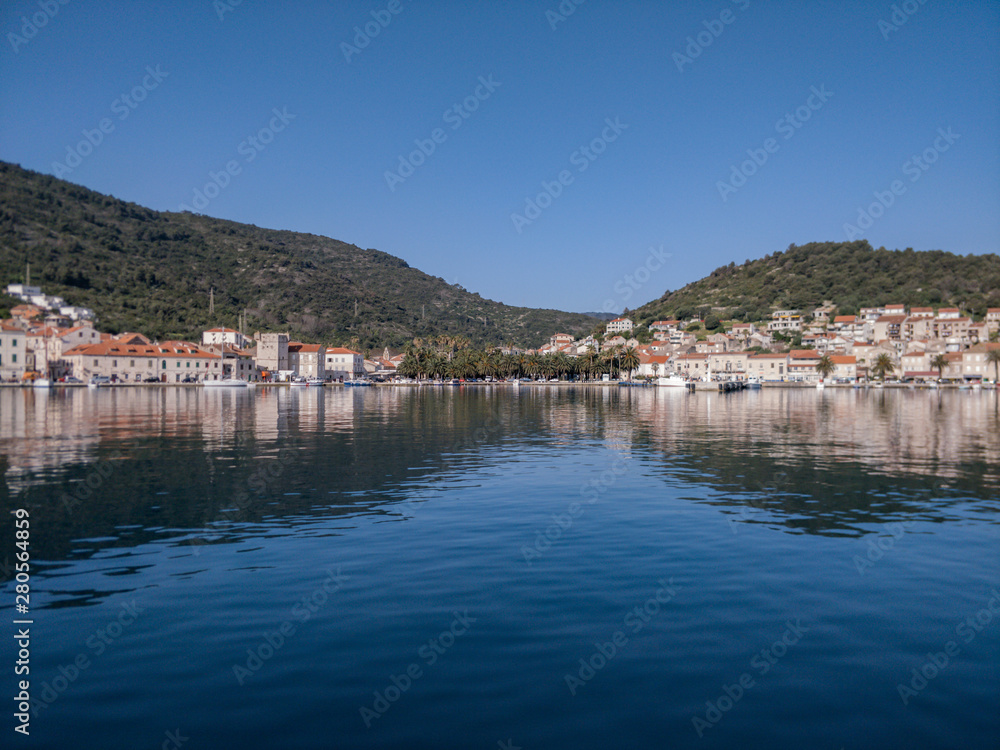 Beautiful seaside village at Croatian coastline shot from boat.