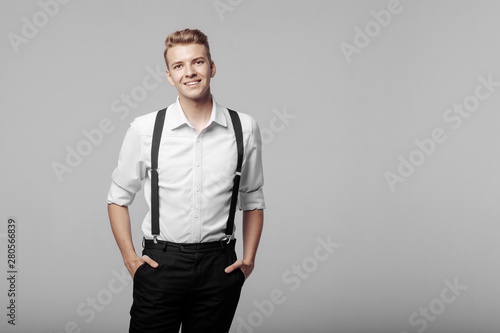 young funny smilling man on gray background in classic style, copy space