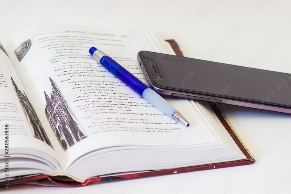 book, pen and phone on a white background book, pen and phone on a white background
