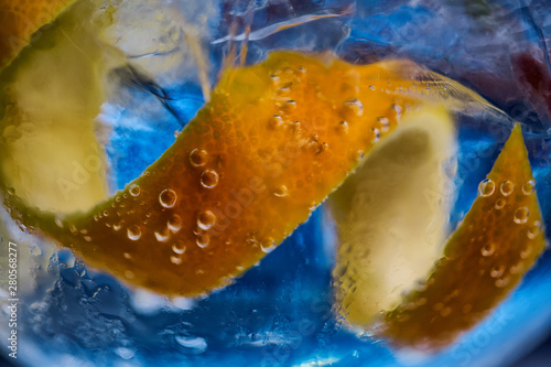 Lemon zest detail inside gina glass with blue tones. photo