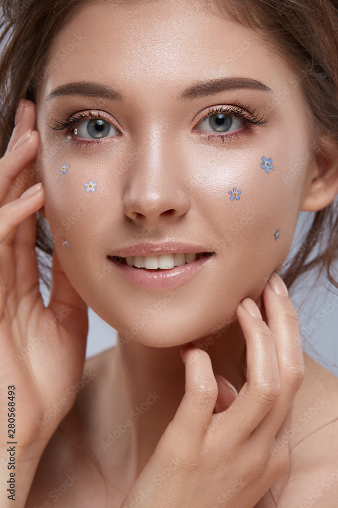 portrait of pretty girl with perfect smile and natural flowers on face portrait of pretty girl with perfect smile and natural flowers on face