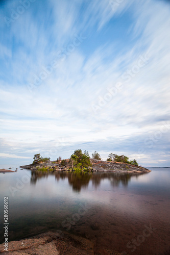 Einsame kleine Insel mit Bäumen im Meer. Little island with trees in the sea at horizon in Background. Sea island panorama. © Lukas Bast