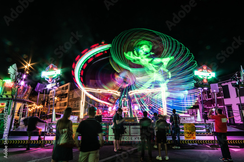 Long exposure carnival ride at night where the lights seemingly create a dancing man