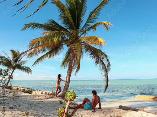 Lovely couple standing near palm trees in paradise Onok Island in Balabac Palawan in Philippines