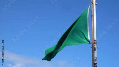 Green flag on the beach informing about safety. The rescuer is present on the beach. You can swim safely.