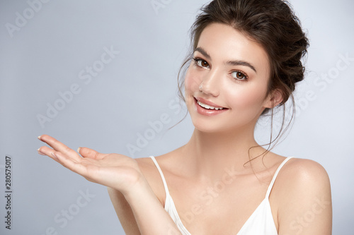 beautiful woman with perfect skin holding her arm for copyspace and smiling