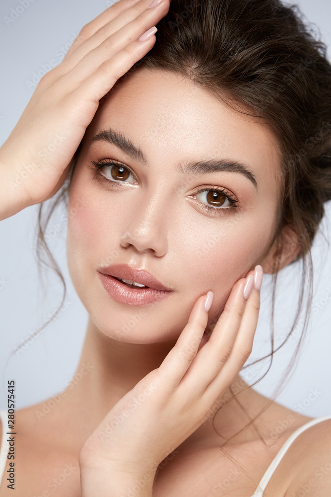 Naklejka premium beautiful woman with perfect make-up and big lips touching her face