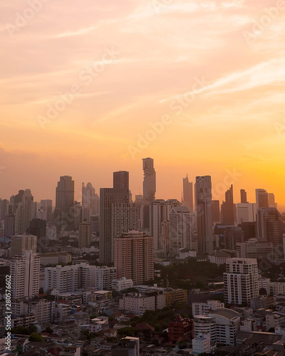 Panorama of cityscape with sunset over the building and blue sky at bangkok ,Thailand. View Vertical of the tall building in capital with twilight .Shot using Panorama technique. © witsawat