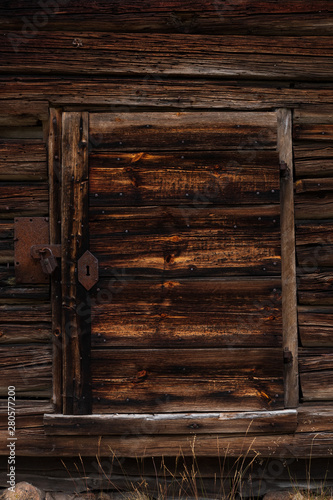 Close up of an old door with a rusty lock on an old abandoned hut inside a Swedish forest close to a lake.