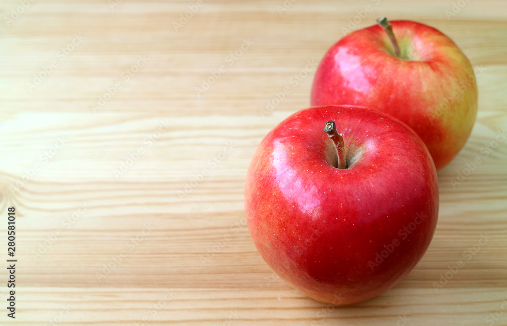 Pair of fresh ripe red apples isolated on natural wooden table with copy space Pair of fresh ripe red apples isolated on natural wooden table with copy space
