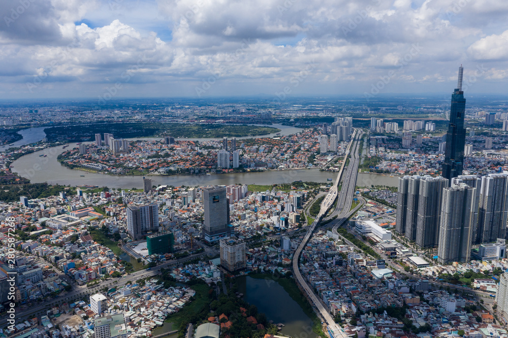 Obraz premium Top View of Building in a City - Aerial view Skyscrapers flying by drone of Ho Chi Mi City with development buildings, transportation, energy power