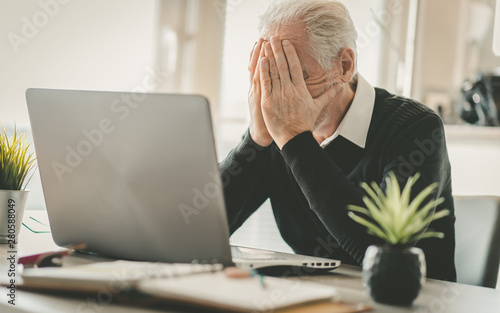 Stressed senior businessman sitting in office