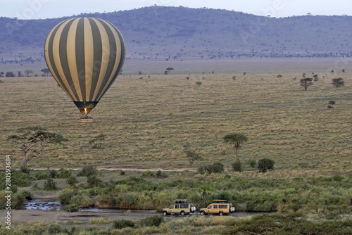 Hot air balloon over river with hippos in Serengeti