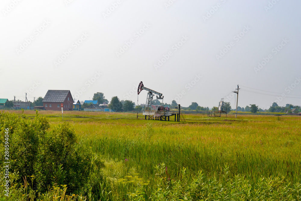 Naklejka premium Crude oil pump in the middle in the center of the field. Oil production in Russia, Republic of Bashkortostan.