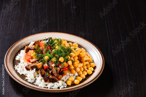 Rice with chickpea and vegetables on wooden table