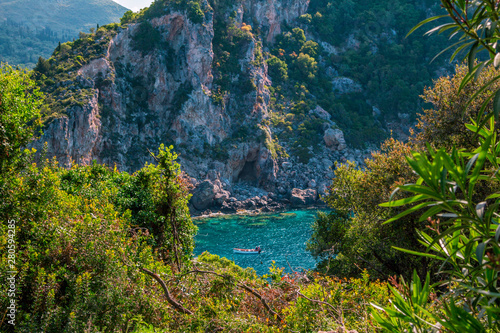 Beautiful landscape with sea   lagoon with turquoise water  mountains  green trees  blooming bushes and flowers. Corfu Island  Greece. 