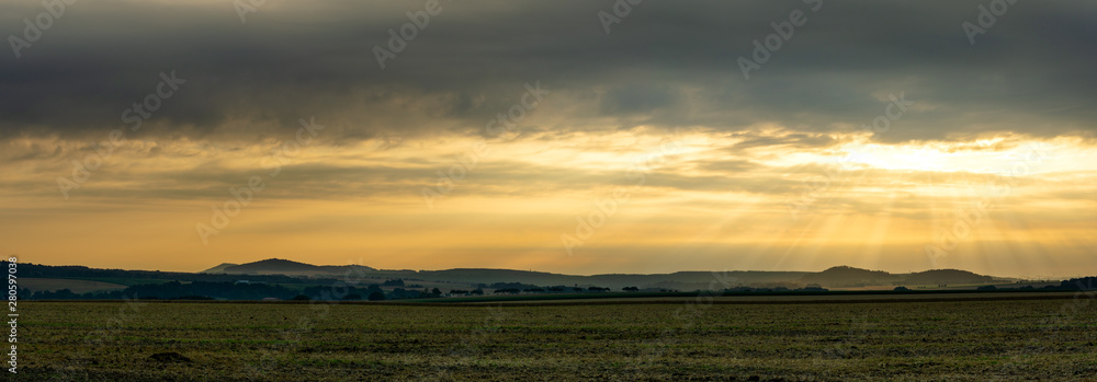 Scenic view on rural landscape in golden morning sunrise with sun rays breaking through the clouds. Upper Lusatia Bernstadt Germany