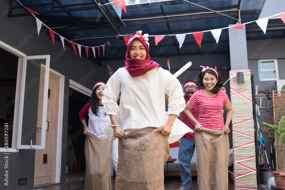 portrait of young asian people compete sack race during indonesia independence day portrait of young asian people compete sack race during indonesia independence day