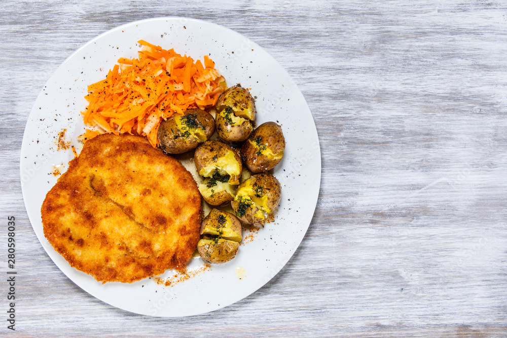 Fried pork chop, boiled potatoes and vegetable salad Fried pork chop, boiled potatoes and vegetable salad
