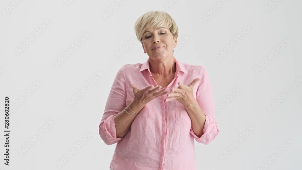 Doubtful blonde senior woman thinking about something and shaking her head while gesturing with hands looking at the camera over gray background isolated Doubtful blonde senior woman thinking about something and shaking her head while gesturing with hands looking at the camera over gray background isolated