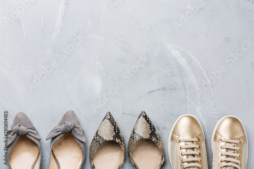 Set of fashionable female shoes on gray background