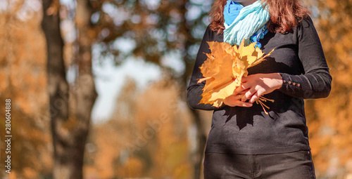 Bouquet of autumn leaves in female hands