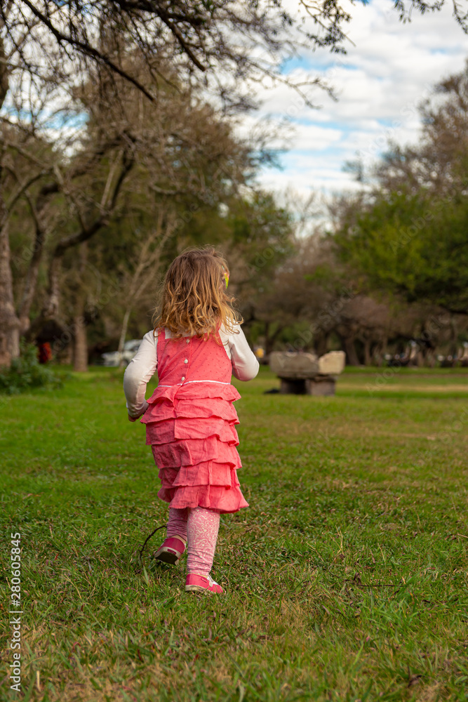 Beautiful little girl running outdoors in an autumn day Beautiful little girl running outdoors in an autumn day