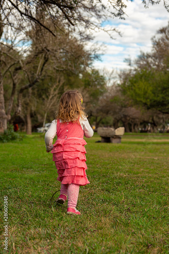 Beautiful little girl running outdoors in an autumn day