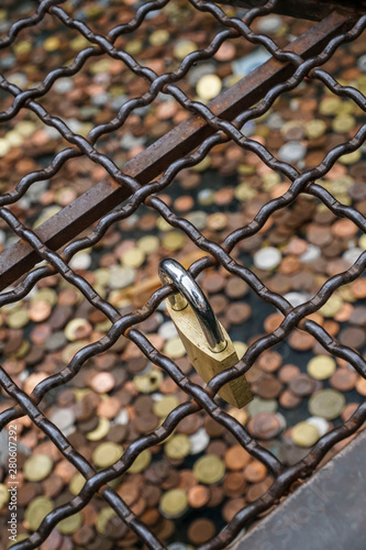 a padlock hanged over coins to making wish