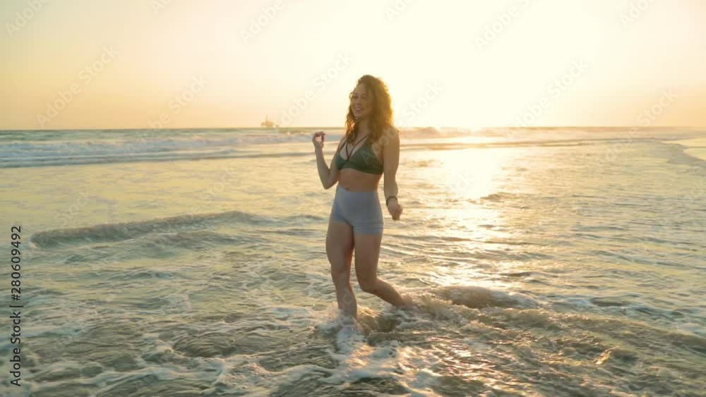 Very fit woman working out on the beach at sunset. Very fit woman working out on the beach at sunset.