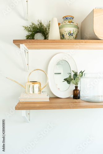 Modern Shelf Decor on Wooden Shelf, Gold Watering Can Decoration, Books, and mirror