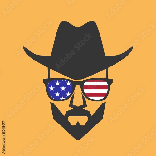 Bearded cowboy in sunglasses and in a hat. Cool American man