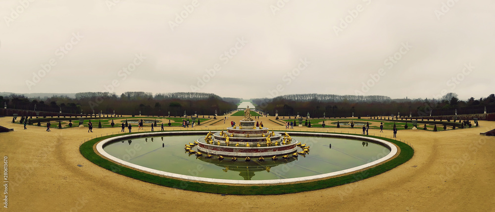 Panorama of Latona Fountain in the Garden of Versailles in France. World Heritage in a cold winter day, bare trees and cloudy sky.