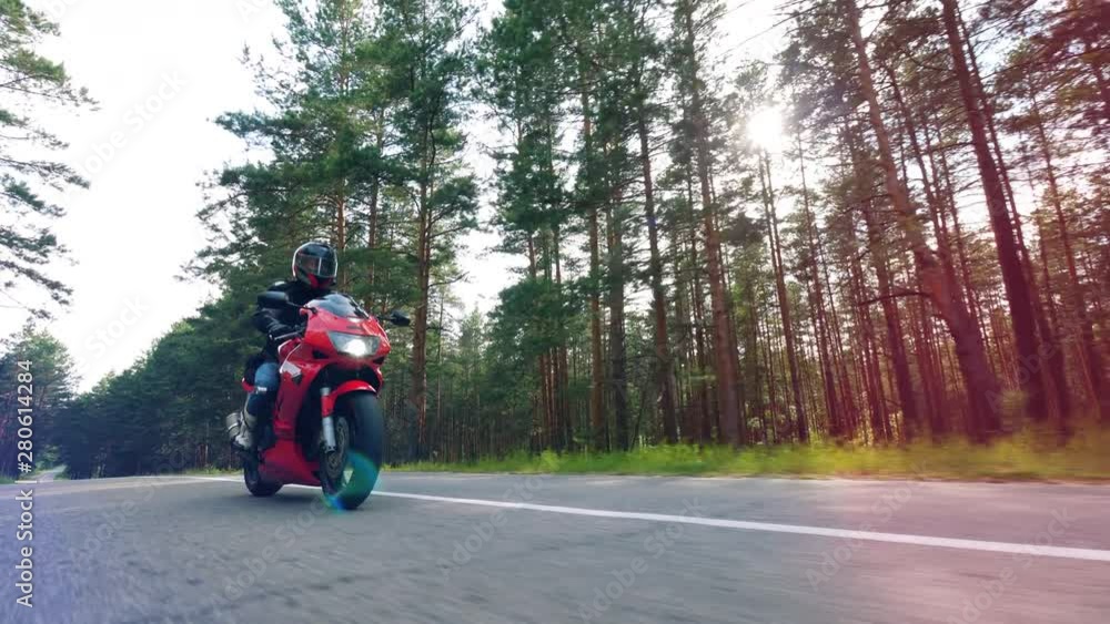 Bike is being driven along the road by a man. Motorcyclist racing his motorcycle. Bike is being driven along the road by a man. Motorcyclist racing his motorcycle.